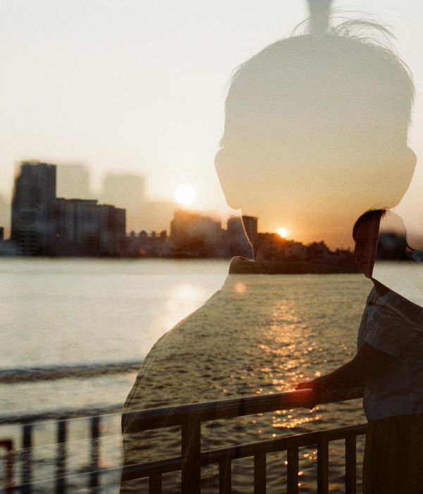 Silhouette of a person meditating against a serene, abstract background.