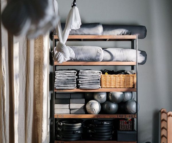 Yoga props like blocks, straps, and blankets neatly arranged in a studio.